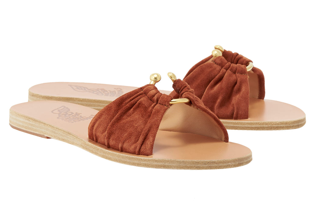 We are delighted to be be stocking Ancient Greek!&nbsp; These beautiful sandals are all hand made in Greece by local craftsman.&nbsp; The Nektaria Slider features deconstructed gold elements on top of a suede slide.&nbsp; Perfect paired with your favourite Summer and Resortwear - you'll want these in every colour!