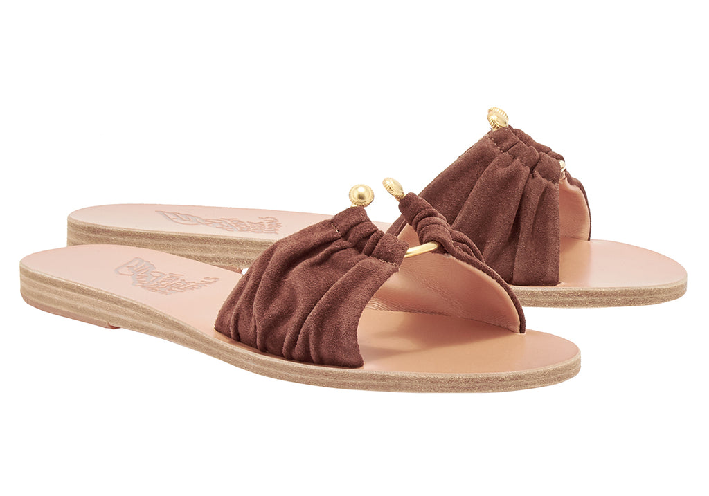 We are delighted to be be stocking Ancient Greek!&nbsp; These beautiful sandals are all hand made in Greece by local craftsman.&nbsp; The Nektaria Slider features deconstructed gold elements on top of a suede slide.&nbsp; Perfect paired with your favourite Summer and Resortwear - you'll want these in every colour!