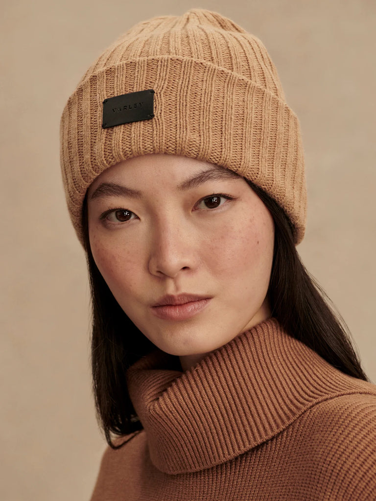 Keep cosy during the colder seasons with the Elva Beanie from Varley. Crafted from a soft merino wool blend, this beanie features a chunky rib texture, a fold-over deep cuff and the Varley logo.