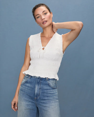 The Devi Top from Paige is crafted from a super soft lightweight cotton/rayon blend and features a sleeveless fitted silhouette, a flattering v neck line, smocking throughout, a tie front and ruffle details.&nbsp; Perfect paired with your favourite denim.