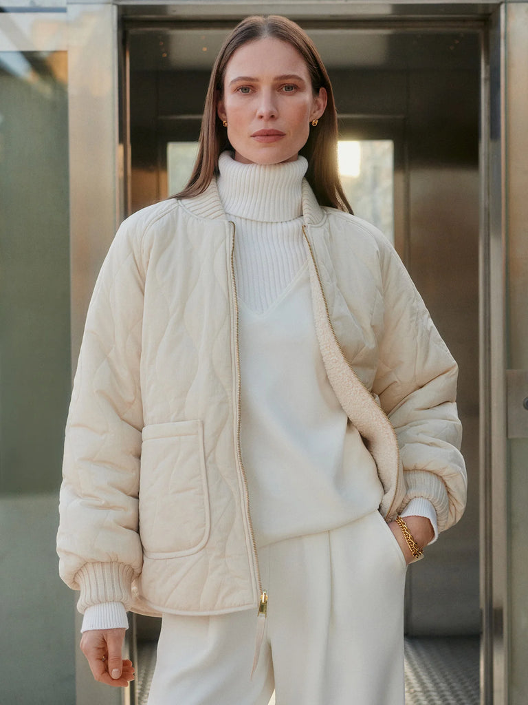 The Serina Reversible Quilt Jacket from Varley is soft, lightweight, and perfect for transitional and cold-weather layering. Made from a tight, curly Bouclé Sherpa fabric on one side and Crinkle Shell fabric in a quilted design on the other, it's cut to a boxy bomber shape with a flattering curved hem. It features pockets and chunky knitted cuffs and collar.