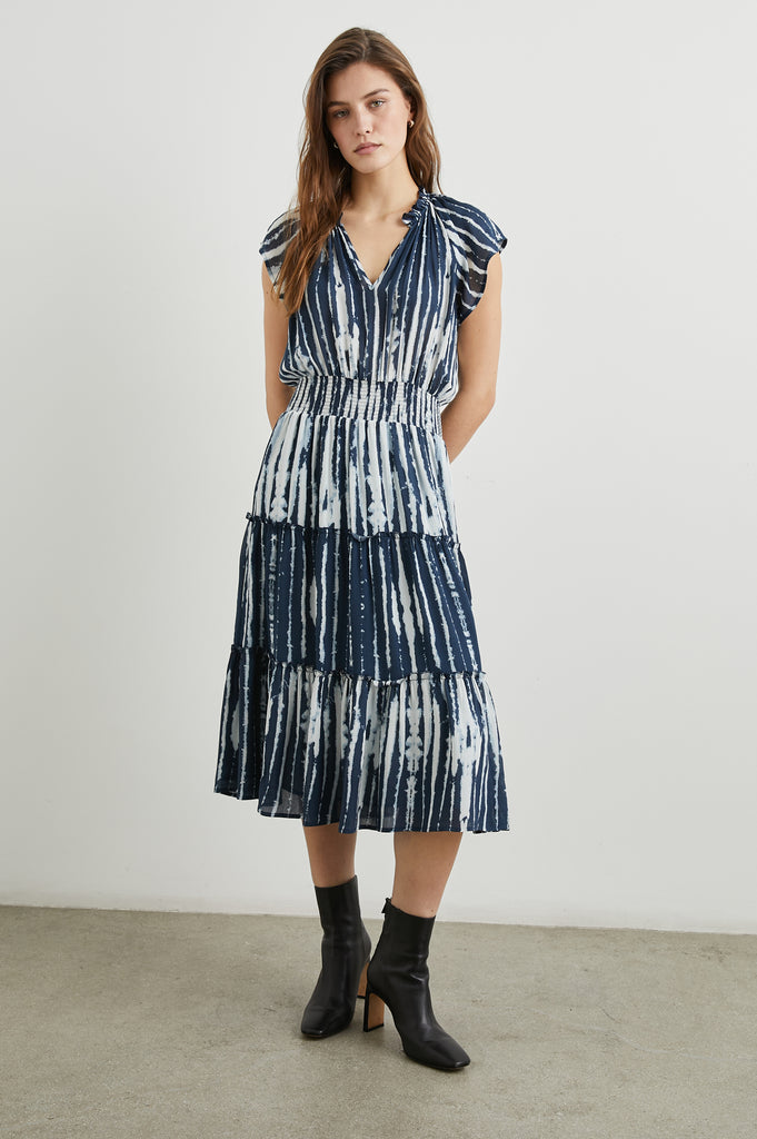 This pretty pullover dress from Rails features a tiered skirt and feminine details. Made from lightweight rayon crepe, this easy to wear midi dress features a flattering v-neckline, elastic at the waist, cap sleeves and ruffle detailing at the neck.&nbsp; &nbsp;Pair with trainers or boots for a great transitional dress.