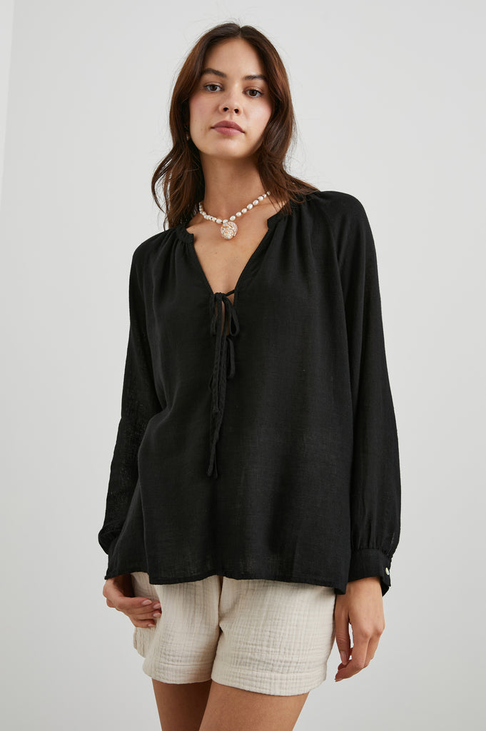 This pretty pullover top from Rails, in easy to wear black is crafted from crisp cotton poplin and features a flattering v neck, raglan sleeves and two adjustable ties at the centre.  A perfect option to throw on with your favourite denim when in a rush but still want to look effortless!