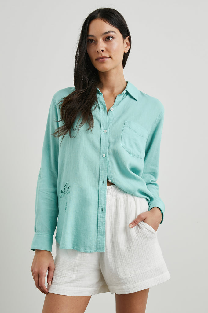 Charli is back in a beautiful aqua colour with a palm tree eyelet detail.&nbsp; A favourite from Rails, the Charli is crafted from a super soft linen and rayon blend. It has a longer hem at the back, a single chest pocket and a relaxed body shape that flatters just about everyone. Pair with your denim for a lazy Sunday afternoon.