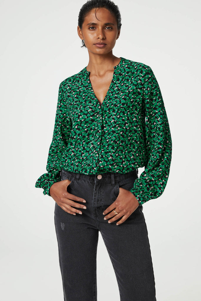 The Frida Isa Blouse from Fabienne Chapot features a button-down front, a v-neckline and cuffed sleeves. This fun green and black printed top looks fab paired with washed black denim and boots. Super easy to dress up or down!