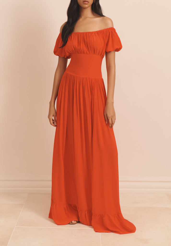 The Hestia Dress from EVARAE is an elegant off-the-shoulder piece that features slight ruched sleeves, a flattering bodice and a smocked back for extra ease and comfort. Effortlessly wear on those warm summer evenings with a cocktail in hand.