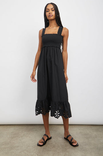 Rumi is back again this year by popular demand!   Crafted from super soft lightweight cotton poplin this sleeveless black midi dress features a flattering square neckline, feminine swingy skirt with ruffle detail at the hem and wide smocked shoulder straps.  Black makes this midi effortlessly elegant.