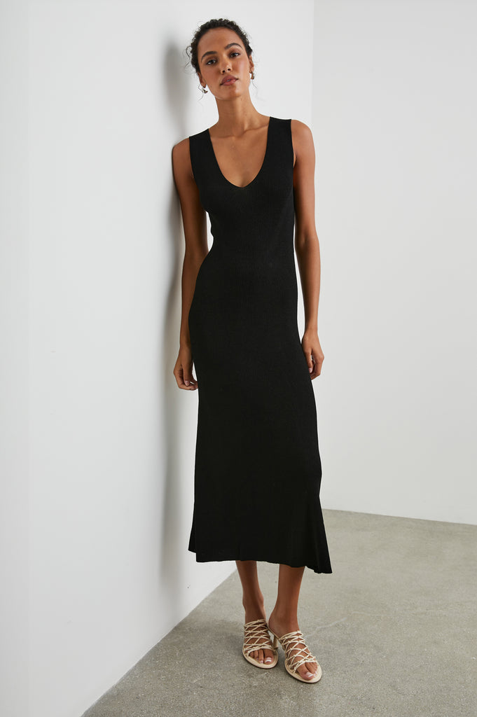 Say hello to your new go to easy to wear Summer black dress!  With a flattering v neck, fitted hourglass shape and ribbing throughout this is one of those dresses that can be dressed up or down!  Pair with cool trainers during the day and slip on some sexy heels for evening!
