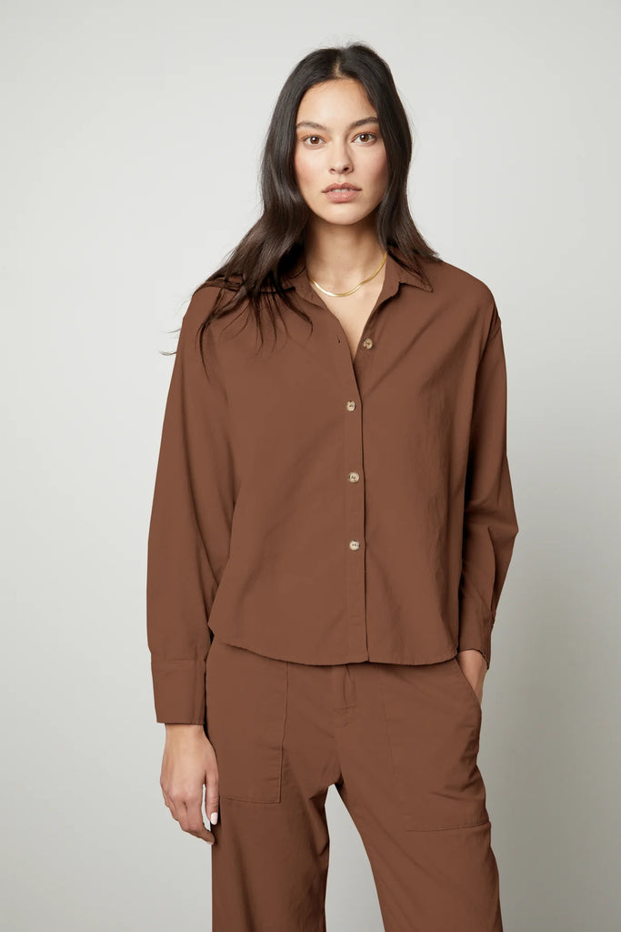 The Jojo Corduroy Shirt from Velvet by Graham & Spencer has a cropped silhouette and features a button up front, a back pleat and a scoop hemline. The cotton cord fabric and relaxed fit makes this shirt comfortable to wear all day long. Style with the matching Vera Trousers.