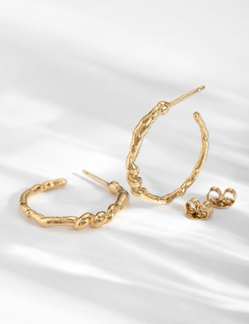 The soft irregular texture of these hoops is meant to represent a pretty vine leaf wrapped around itself.  Crafted from tin gilded with 24k fine gold and made by hand in Louise Damas' workshop in Paris the fastening rods are 925 silver thus avoiding risk of allergy. 