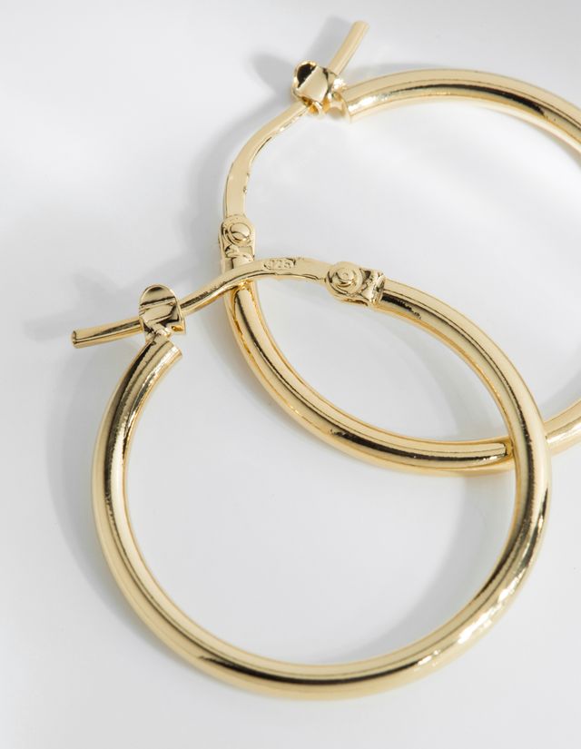 The Augustine mid sized hoop earrings literally will go with everything.   Handcrafted in Louise Damas' Paris workshop these lovely earrings are gilded in recycled 24k fine gold RJC certified onto brass. They have a 20mm diameter and the clasps and rods are 925 silver thus avoiding risk of allergy.  