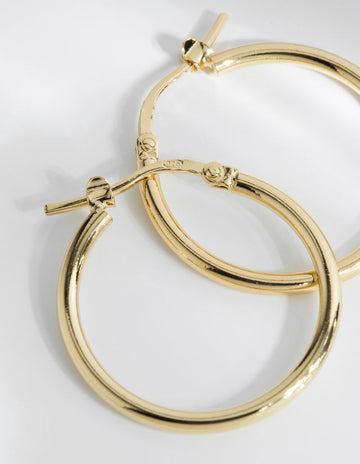 The Augustine mid sized hoop earrings literally will go with everything.   Handcrafted in Louise Damas' Paris workshop these lovely earrings are gilded in recycled 24k fine gold RJC certified onto brass. They have a 20mm diameter and the clasps and rods are 925 silver thus avoiding risk of allergy.  