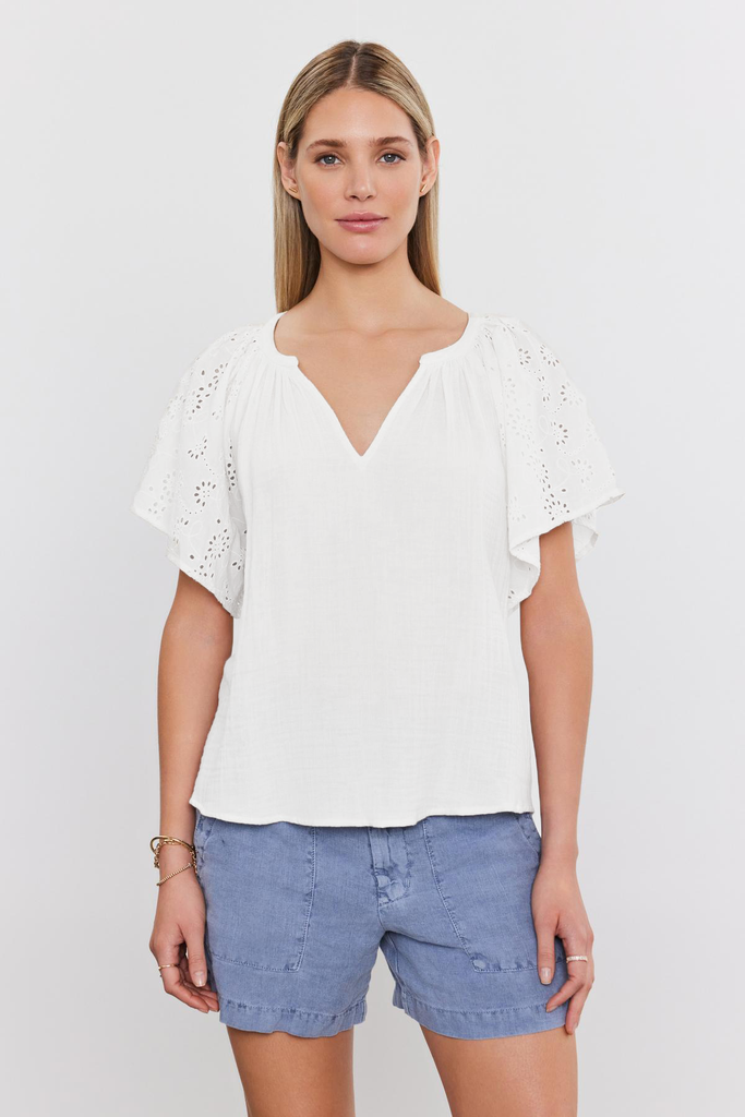 The Tish top from Velvet by Graham &amp; Spencer is crafted from their signature super soft cotton gauze and features embroidered eyelet flutter sleeves and a flattering v neck.&nbsp; Charming and effortless this is perfect paired with your favourite shorts for when the temperatures heat up!&nbsp; Also available in store in black.