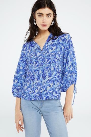 The Cooper Blouse from Fabienne Chapot features a fun blue palm print, elbow length sleeves with bow detail, button fastenings down the centre and a v-neckline. Style this easy blouse with jeans and trainers or dress up with a bias skirt and espadrilles. 