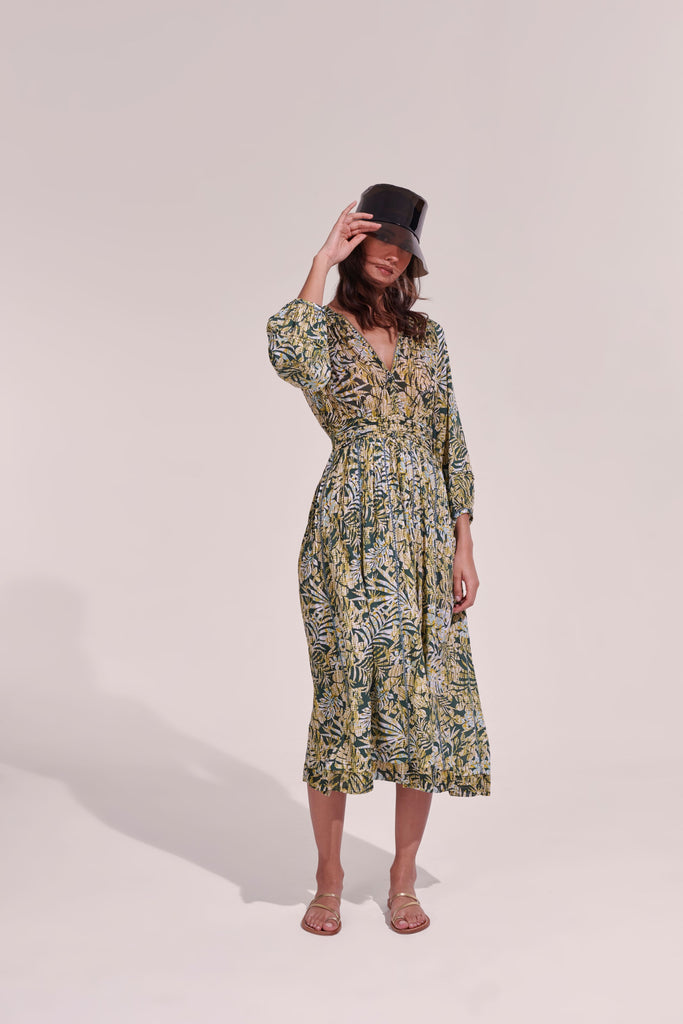 The Anabelle midi dress from Poupette St Barth features transparent long sleeves, a straight skirt and pleats at the shoulders and waist. The deep v neckline continues to the back of the dress and is finished beautifully with a delicate trim. Wear with trainers or heeled sandals - this dress can take you day to night.