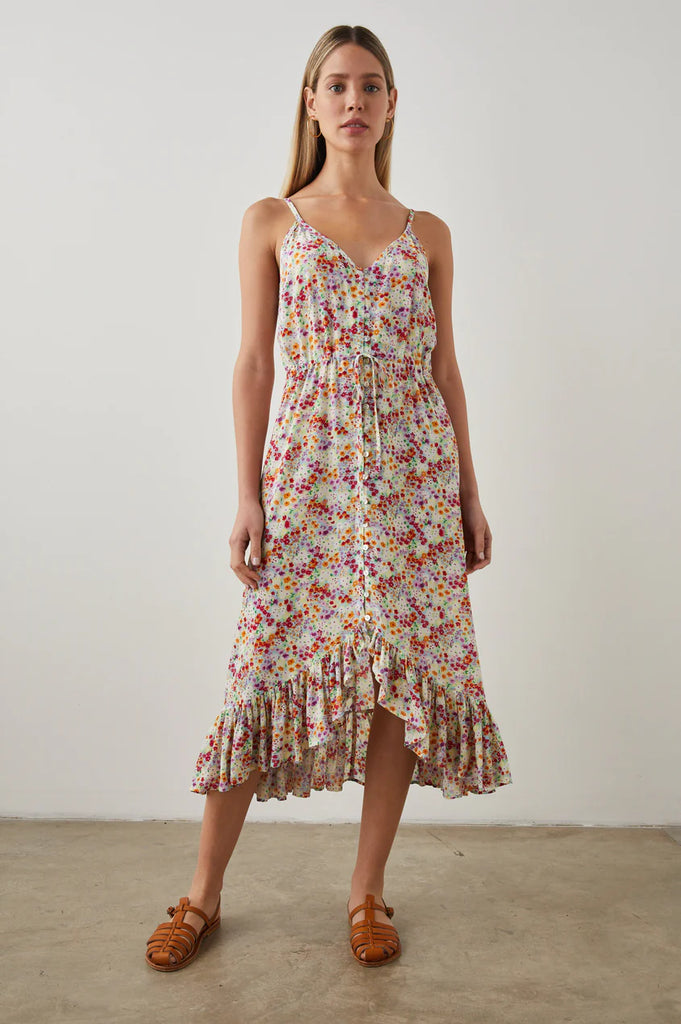 The Frida Dress from Rails is a sleeveless midi in a pretty multi-coloured floral print. It features thin adjustable shoulder straps, fabric covered buttons down the centre, a drawstring waist and a high-low ruffle hem. Feminine and flowy, this style is the perfect day dress.