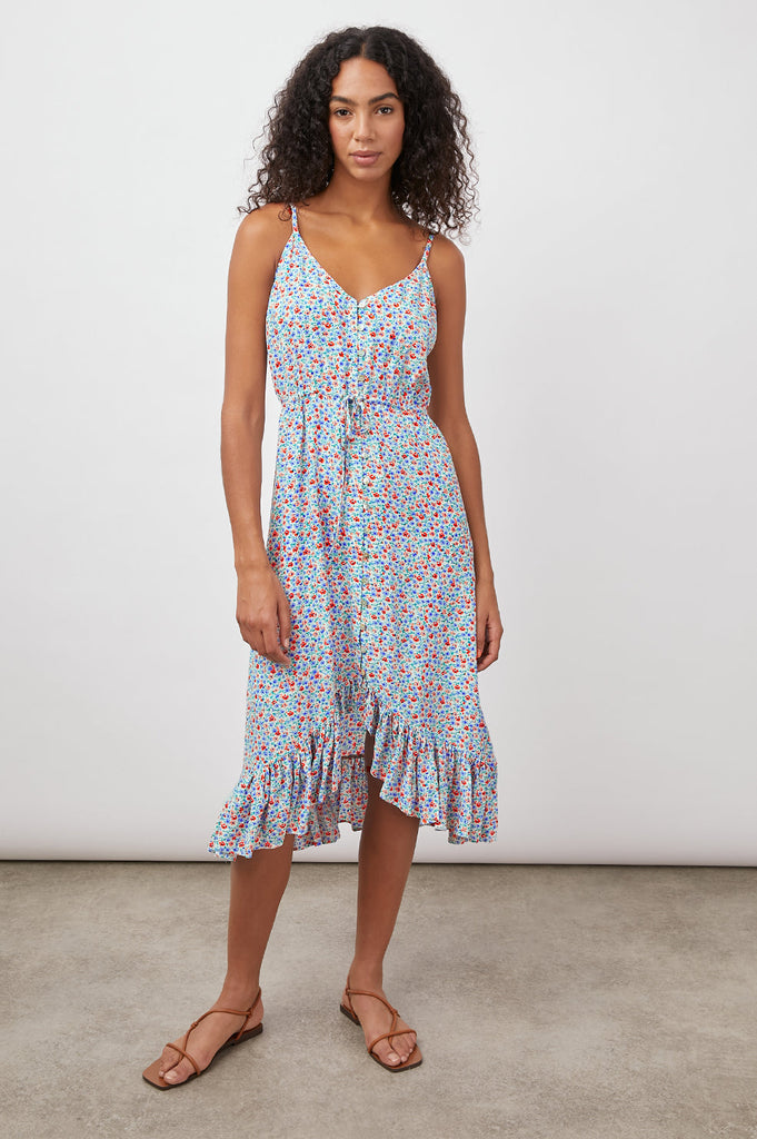 This lightweight, sleeveless midi dress from Rails features a pretty floral print, a swingy fit, a v-neckline, thin adjustable shoulder straps, a high-low hem with ruffle detail and fabric covered buttons. This dress is both feminine and flattering and the perfect throw-on-and-go staple for any occasion.
