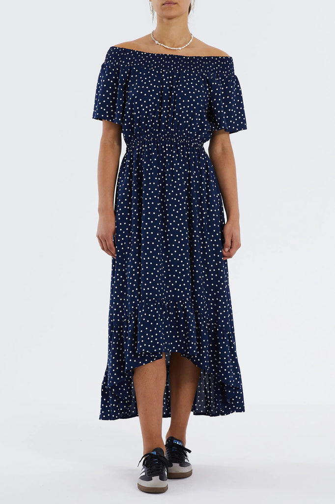 The Flora Dress from Lollys Laundry features a smocked off the shoulder style, an elasticated waist and a ruffle hem. With a high-low hem this dress is romantic with a twist. Wear with trainers or a heel for day-to-night styling.