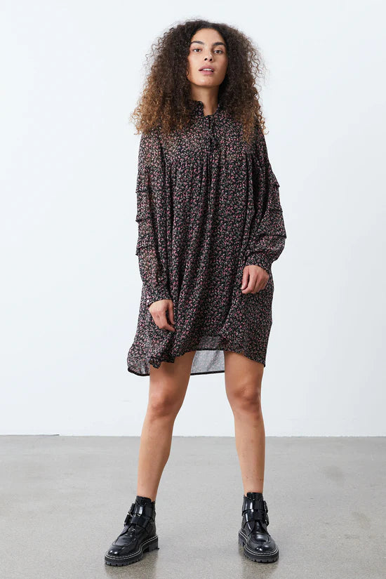 The Georgia Dress from Lollys Laundry is the cutest short dress with a voluminous fit. It is designed with long sleeves and a v-neckline with a tie detail to close it up if preferred, it also features a delicate small frill detail. Pair with tights and boots for easy transitional styling. 