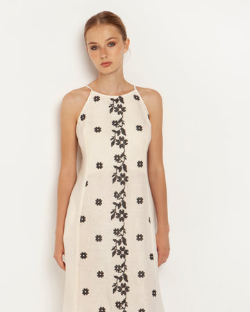 This beautiful daisy embroidered midi dress from Greek Archaic Kori features a halter-style neckline with a smocked keyhole tie back. It has adjustable straps and a slight A-line shape.  Pair with your favourite espadrilles for an elegant summer look.   