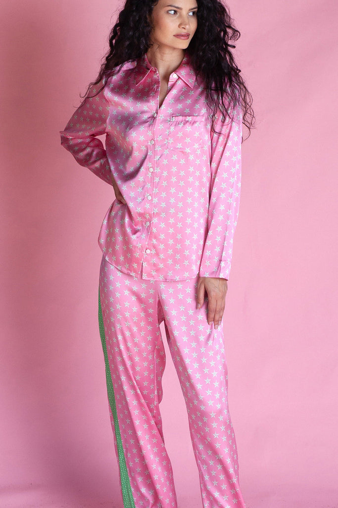 This luxurious PJ set features pretty white stars on a pink background. The 95% silk fabric top has a button-down front and a pocket detail. The accompanying bottoms feature a drawstring tie and contrasting green trim.  These are super feminine, flirty and fun!