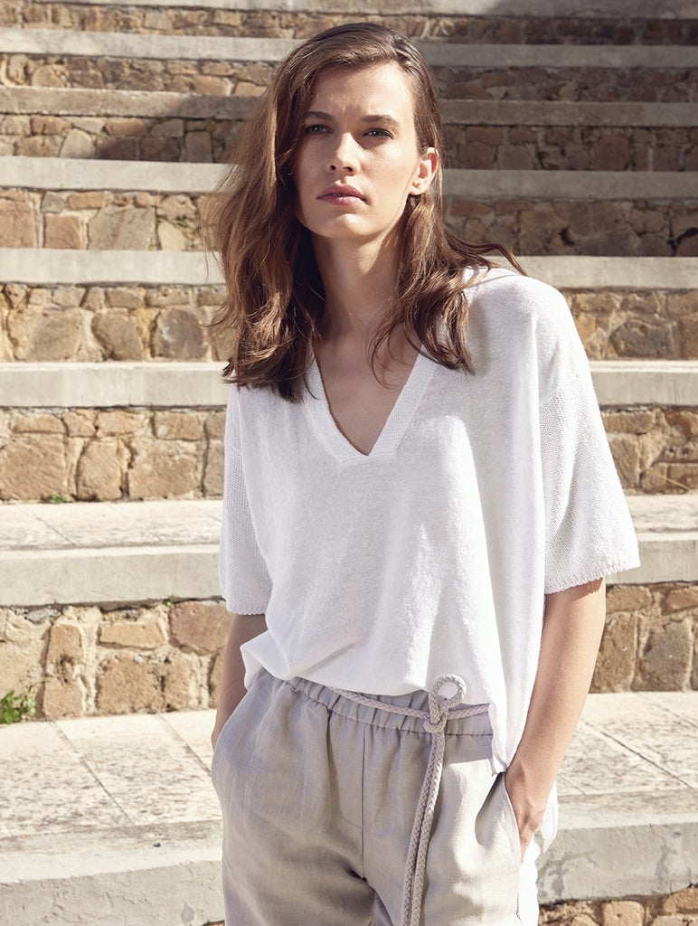 This White Pullover from Le Tricot Perugia is crafted in a linen and cotton mix, featuring subtle sequin details within a knit across the neckline and arms. The V-neck and two small side slits make this pullover flattering as well as classy. Also available in navy in store.