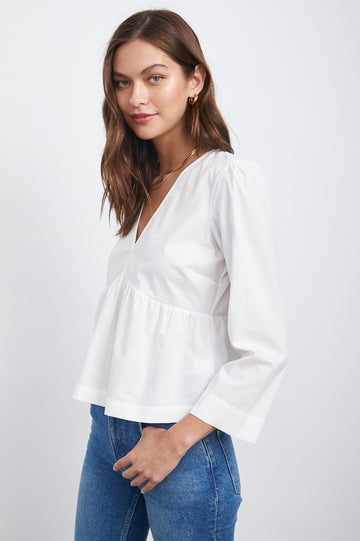 The Noella Blouse from Rails is crafted from a light-weight cotton poplin and features a gathered empire waist, a v-neckline and long straight-cut sleeves. The baby-doll cut creates a flouncy and feminine look, great for everyday wear!