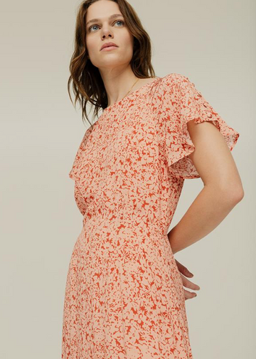 The Rae Dress is the bestselling signature shape from Lily and Lionel.  Shown here in a gorgeous blush pink print and crafted from a super soft sustainable viscose crepe this is a lovely dress which moves gracefully when on the body.  Featuring a subtle frill at the hem, floating sleeves with a button detail and a centre back button closure this is a flattering shape and will look equally fab with trainers or a pretty sandal.