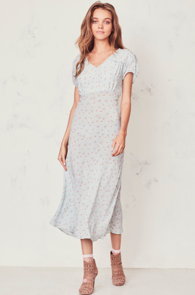 The Meg Midi Dress from Love Shack Fancy radiates romance in washed silk crepe with a vintage-inspired tea rose print. This modern take on an old-fashioned country frock features a small ruffle detail that extends from the trimmed v-neck to classic puffed cap sleeves on each side. At the waist, a generous sash can be tied in a bow at front or back. An easy fit skirt falls to mid-calf.