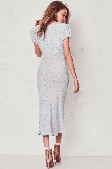 The Meg Midi Dress from Love Shack Fancy radiates romance in washed silk crepe with a vintage-inspired tea rose print. This modern take on an old-fashioned country frock features a small ruffle detail that extends from the trimmed v-neck to classic puffed cap sleeves on each side. At the waist, a generous sash can be tied in a bow at front or back. An easy fit skirt falls to mid-calf.