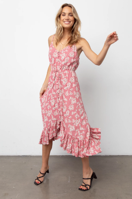 Sleeveless, V-neck, midi-length pink floral printed dress featuring thin adjustable shoulder straps, fabric covered buttons down the center front, a drawstring self-tie waistline, and a flowy bottom hem. Soft skirt lining. Feminine and flowy, this style is the perfect day-to-night dress. 