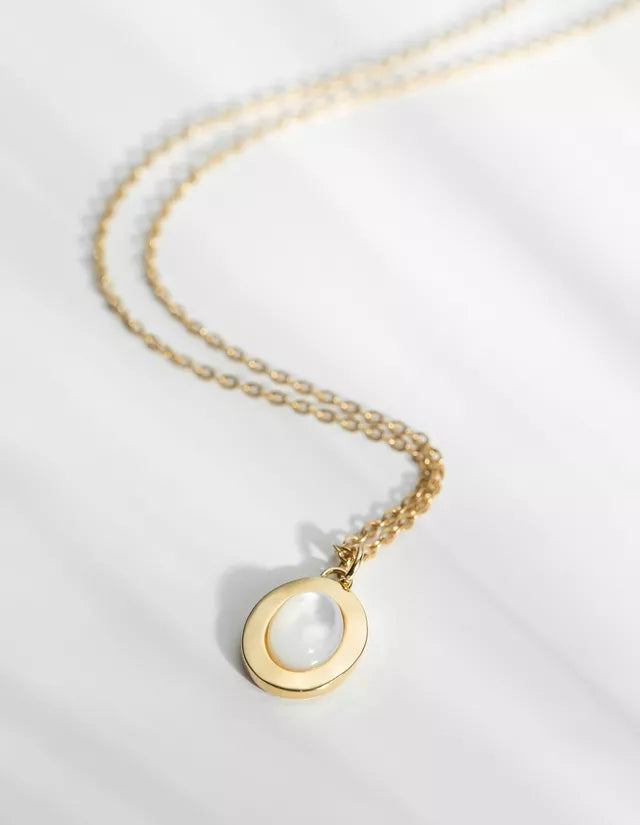 The Lise Medal Necklace has a long thin chain made of brass and gilded with 24k fine gold. Featuring a natural mother-of-pearl cabochon, the Lise medal is as elegant as it is discreet. This pearly medal twirls lightly and dresses the skin with beautiful iridescent reflections.