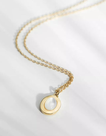 The Lise Medal Necklace has a long thin chain made of brass and gilded with 24k fine gold. Featuring a natural mother-of-pearl cabochon, the Lise medal is as elegant as it is discreet. This pearly medal twirls lightly and dresses the skin with beautiful iridescent reflections.