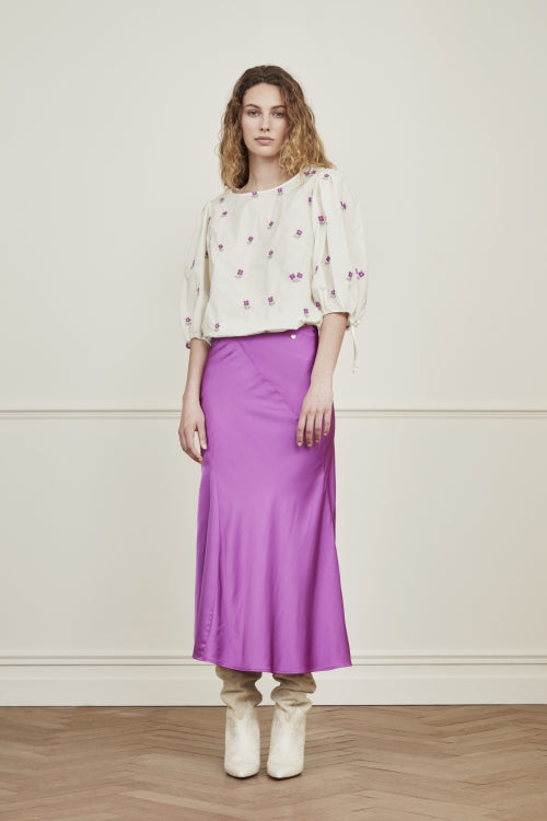 The Suzy Midi Skirt from Fabienne Chapot is crafted in a beautiful purple satin. Featuring diagonal seems, an inner-lining and a dainty heart detail, this bias skirt is perfect for any occasion. Dress up with a blouse and heels or dress down with a t-shirt and trainers. 