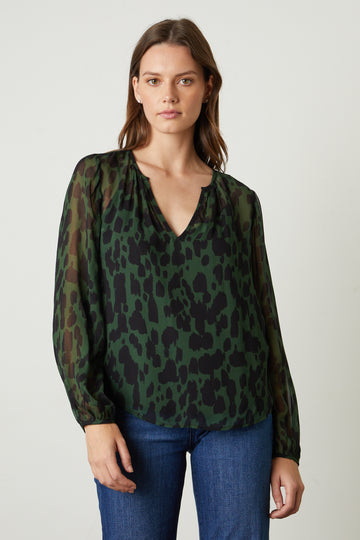 The Edna Blouse in Airbrush from Velvet by Graham & Spencer features a v-neckline and long sleeves with a delicate buttoned cuff. The jeans and a nice top combination never goes out of style and this is a perfect one to add to your collection. 